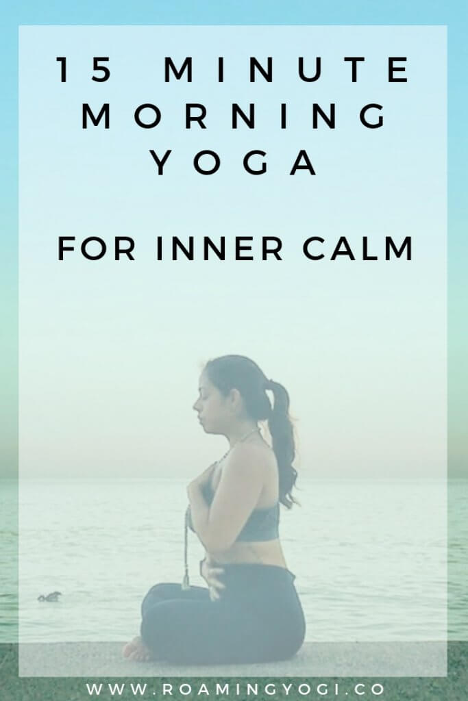Image of a young woman in a seated meditation pose with one hand over her heart and one hand over her belly, with text overlay: 15 Minute Morning Yoga for Inner Calm. www.roamingyogi.co